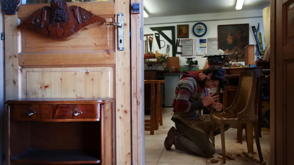 Artisan qui restaure une chaise dans son atelier