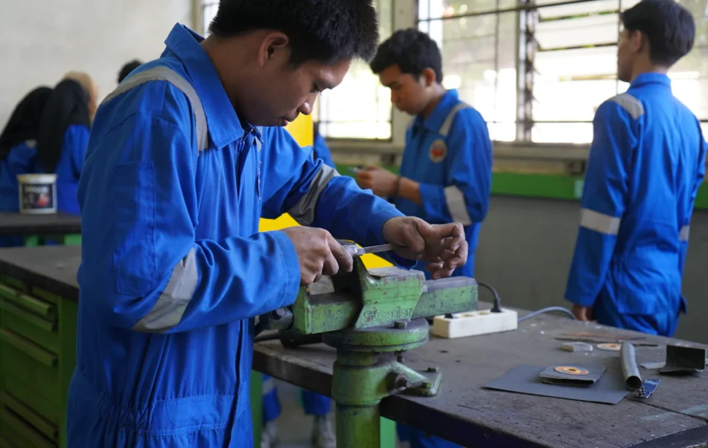 Apprentis en bleu de travail à l’établi