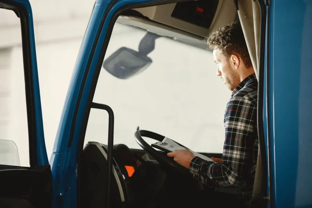 Chauffeur poids lourd qui lit ses documents dans la cabine